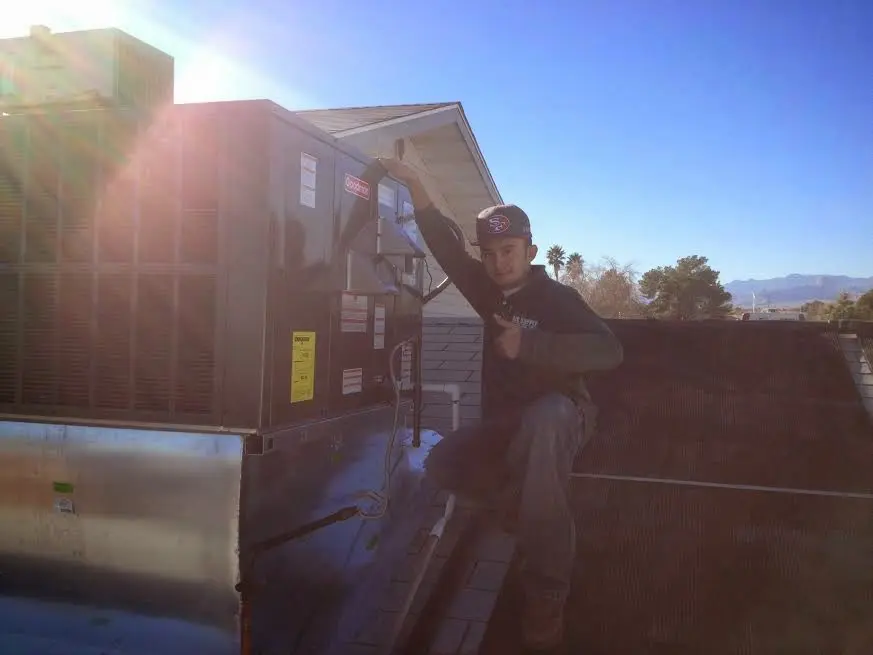 HVAC technician performing AC Tune-Up on a rooftop unit in Angola